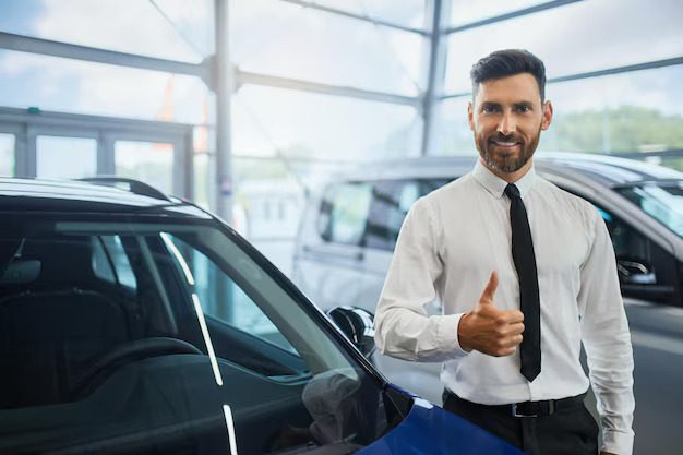 handsome-man-showing-thumb-up-while-buying-car-salon_7502-9630